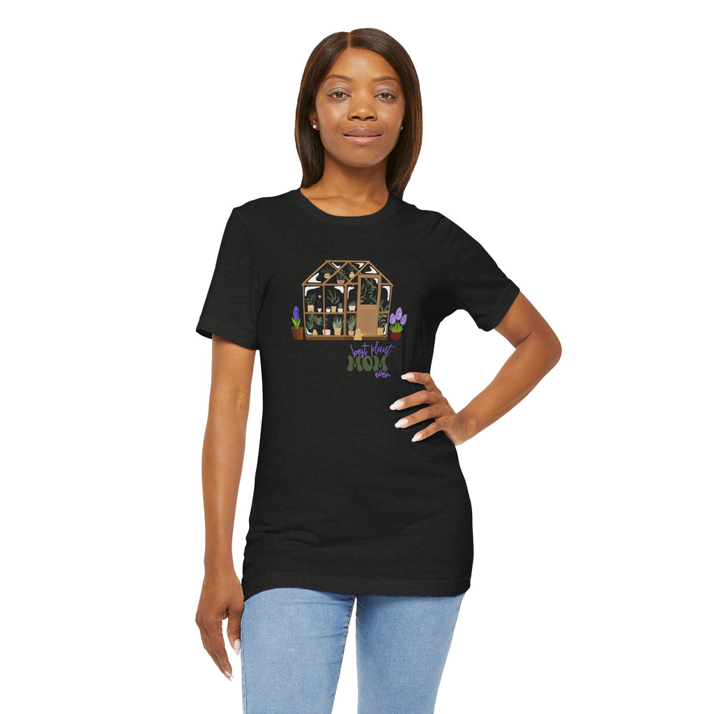 a person wearing a black shirt with a greenhouse design and the words "best plant mom ever."  