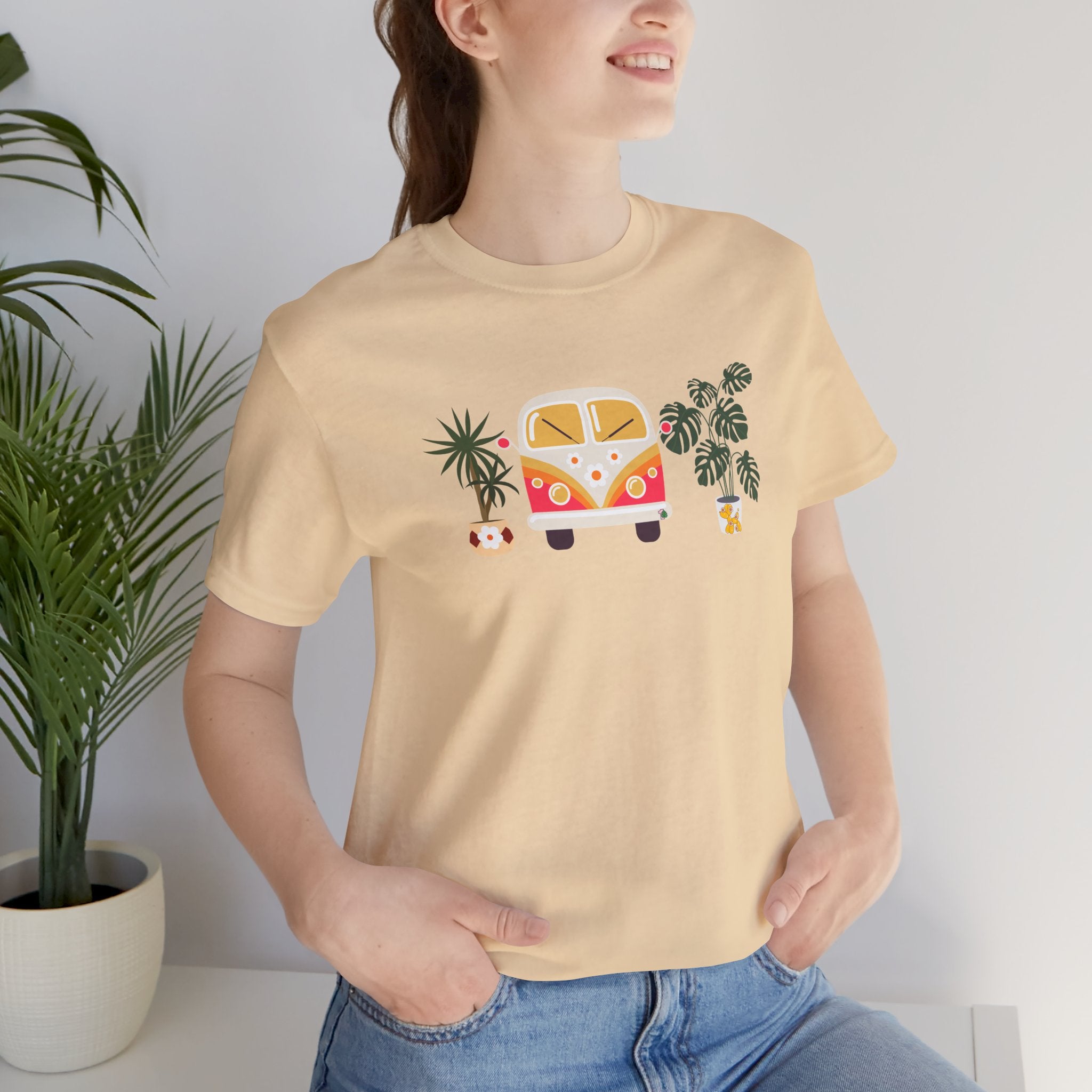 A person wearing a graphic tee with plant designs and a vintage buggy car. 