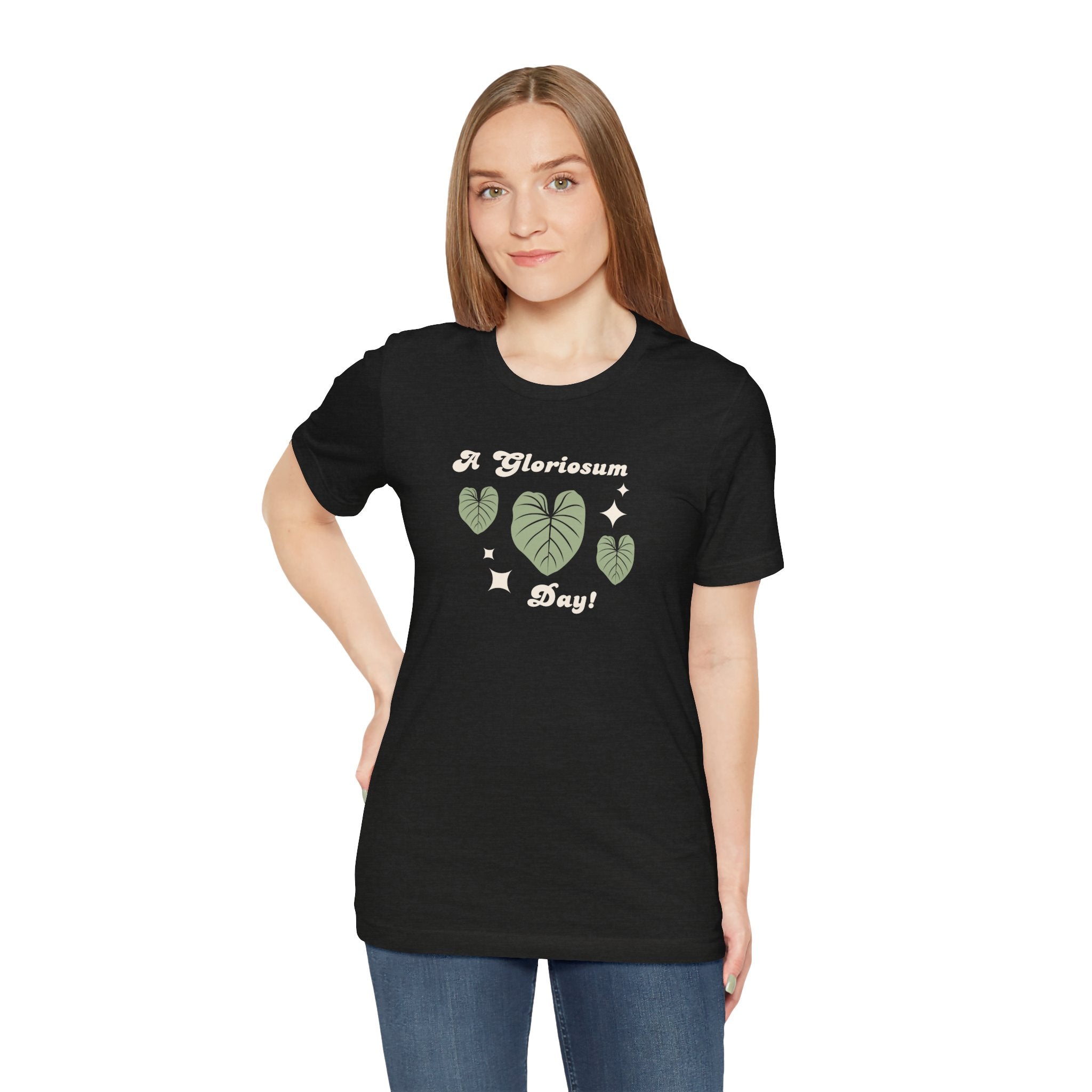 A person wearing a plat top with a philodendron gloriosum design and text that says "A gloriosum Day!" An excellent gift for plant lovers, plant collectors, and plant enthusiasts. Great as a birthday gift. This folded t-shirt comes in a black Heather color.