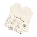 A folded tshirt in a natural colored tone and a printed design of birth flowers.  Each month of the year is printed with a corresponding flower for that particular month.  The t-shirt has a crew neck and short sleeves.  It is also lightweight so it's perfect for layering.  It also makes an excellent birthday, Mother's Day, Valentine's Day or Christmas gift. 