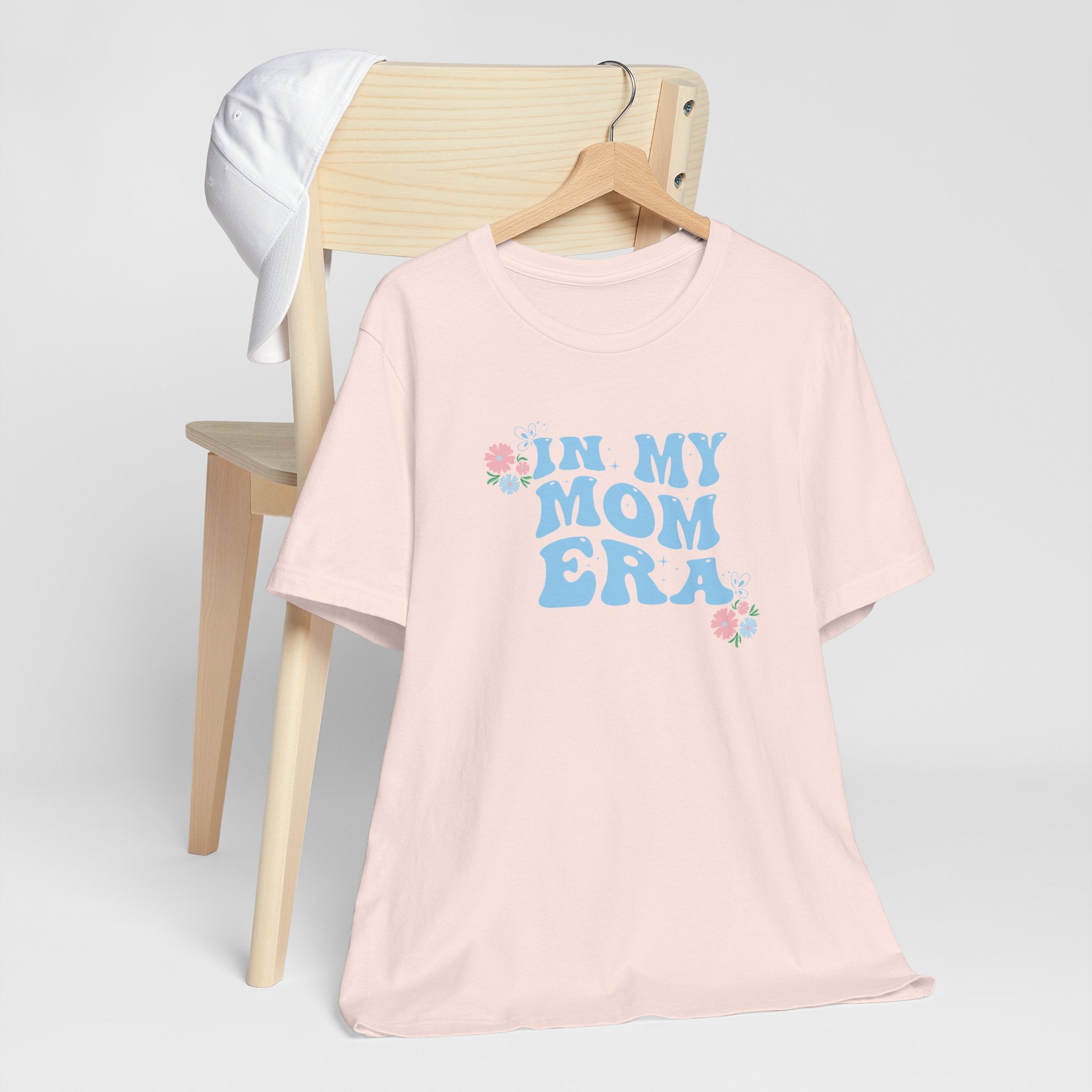 a pink tee shirt with the words "In my mom era" printed in blue. This shirt makes an excellent t-shirt for soon to be moms.